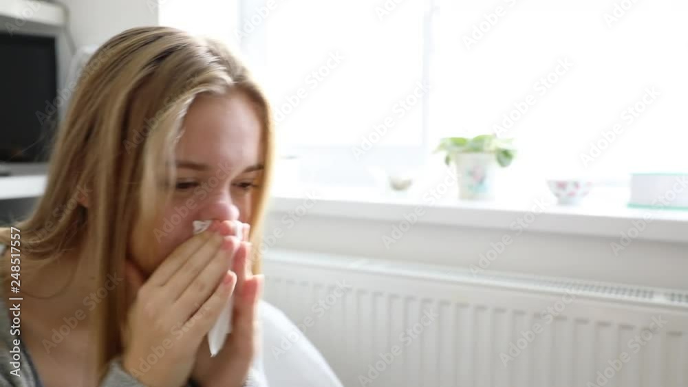 Teenage girl having a cold, blowing her nose Teenage girl having a cold, blowing her nose
