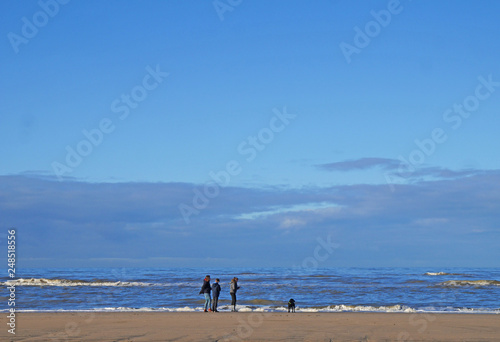 
family walking the beach with the dog