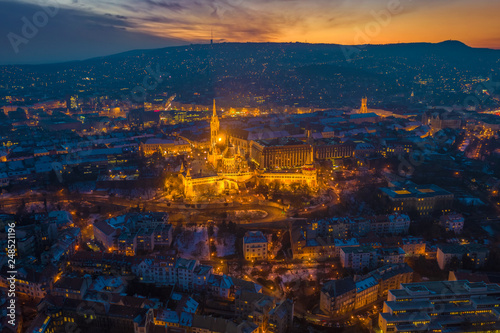 Budapest, Hungary - Aerial view of the illuminated Fisherman's Bastion (Halaszbastya) and Matthias church at Buda district with beautiful sunset over the Buda Hills