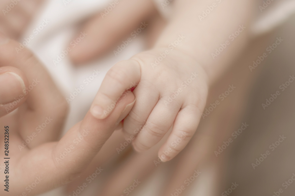 gentle touch of the hands of mothers and pens of a newborn baby. close-up. Blur gentle touch of the hands of mothers and pens of a newborn baby. close-up. Blur