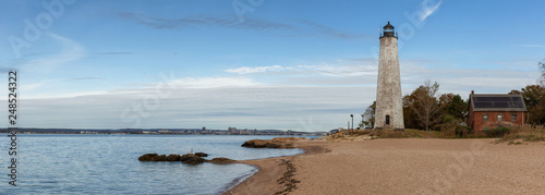 Panoramic view on a lighthouse on the Atlantic Ocean Coast during a cloudy morning. Taken in Lighthouse Point Park, New Haven, Connecticut, United States.