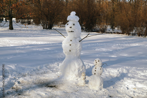 Symbol of winter: a family of snowmen in the park. Winter scenes.