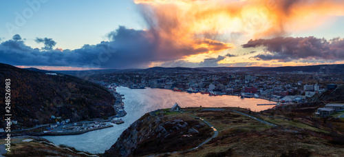Aerial panoramic view of a modern cityscape on the Atlantic Ocean Coast during a dramatic sunset. Taken in St. John's, Newfoundland and Labrador, Canada.