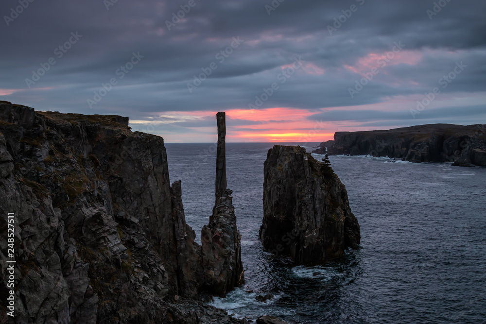 Beautiful seascape of a rocky Atlantic Ocean Coast during a cloudy sunrise. Taken in Spillars Cove, Bonavista, Newfoundland and Labrador, Canada.