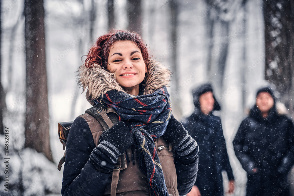 Red-haired student travels with friends in the Snowy forest Red-haired student travels with friends in the Snowy forest