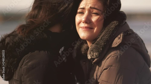 Sad woman crying hugging mother closeup slow motion photo