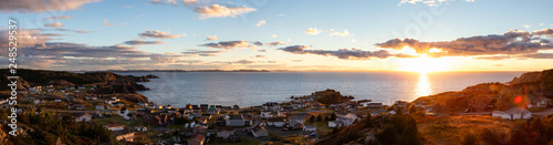 Panoramic view of a small town on the Atlantic Ocean Coast during a vibrant sunset. Taken in Crow Head, North Twillingate Island, Newfoundland and Labrador, Canada.