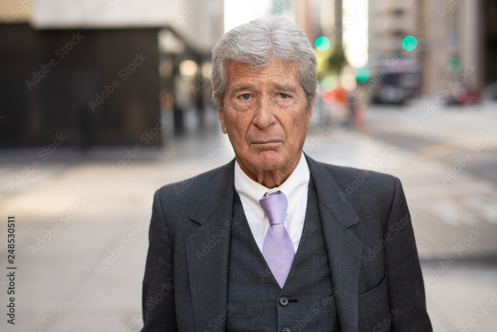 Senior businessman in city serious angry face