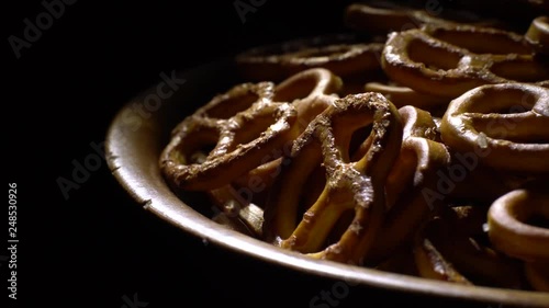 Pretzel salted in rotation. Close up. Studio shot. Black background. Unhealthy diet concept. Junk food concept.