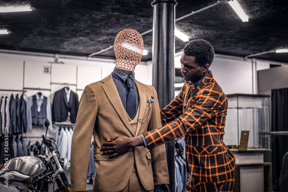 Stylish African-American man dressed in trendy elegant suit, working at classic menswear store. Stylish African-American man dressed in trendy elegant suit, working at classic menswear store.