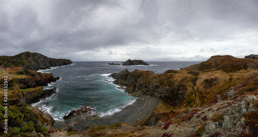 Panoramic landscape view of a Rocky Atlantic Ocean Coast during a cloudy day. Taken in Sleepy Cove, Crow Head, Twillingate, Newfoundland, Canada.