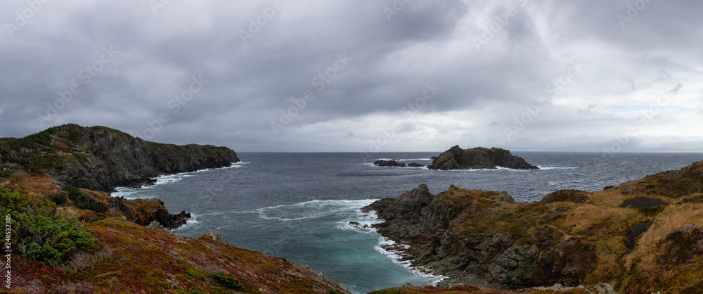 Panoramic landscape view of a Rocky Atlantic Ocean Coast during a cloudy day. Taken in Sleepy Cove, Crow Head, Twillingate, Newfoundland, Canada.
