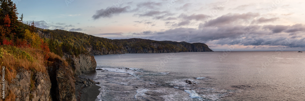 Striking panoramic landscape view of a rocky Atlantic Ocean Coast during a vibrant sunrise. Taken at Beachside, Newfoundland and Labrador, Canada.