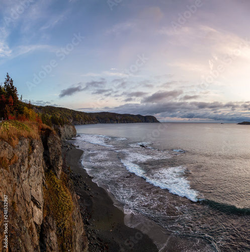 Striking panoramic landscape view of a rocky Atlantic Ocean Coast during a vibrant sunrise. Taken at Beachside, Newfoundland and Labrador, Canada.