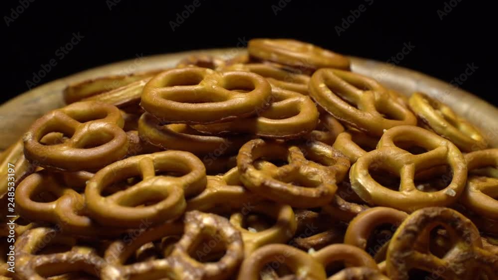 Pretzel salted in rotation. Close up. Studio shot. Black background. Unhealthy diet concept. Junk food concept. Pretzel salted in rotation. Close up. Studio shot. Black background. Unhealthy diet concept. Junk food concept.