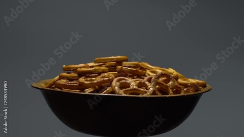 Pretzel salted in rotation. Close up. Studio shot. Grey background.  Unhealthy diet concept. Junk food concept.