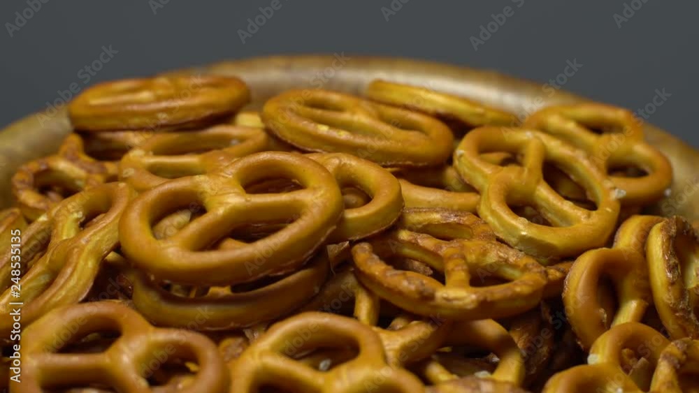 Pretzel salted in rotation. Close up. Studio shot. Grey background. Unhealthy diet concept. Junk food concept. Pretzel salted in rotation. Close up. Studio shot. Grey background. Unhealthy diet concept. Junk food concept.