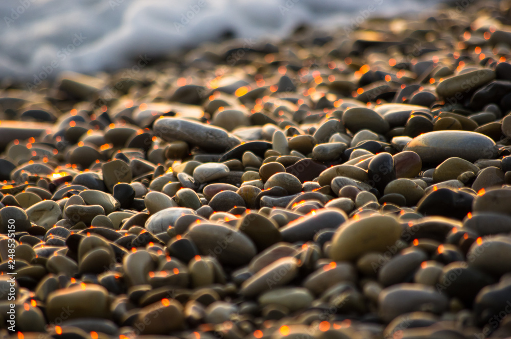 Obraz premium pebble stones on the sea beach, the rolling waves of the sea with foam