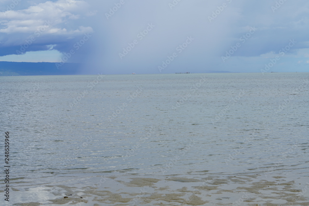 View of a storm in the distance at Manjuyod Sandbar, Philippines View of a storm in the distance at Manjuyod Sandbar, Philippines
