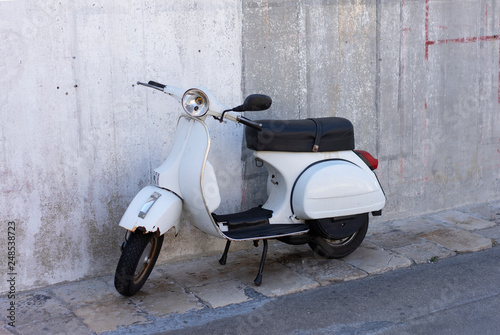 Old scooter on concrete wall background