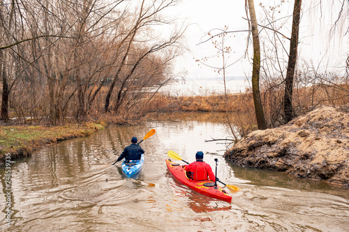Two persons kayaking in calm water without running