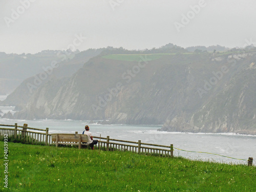 Pilgrim watching at the horizon, La Puenta de Cuerno in Cadavedo, Northern St. James Way, Spain photo