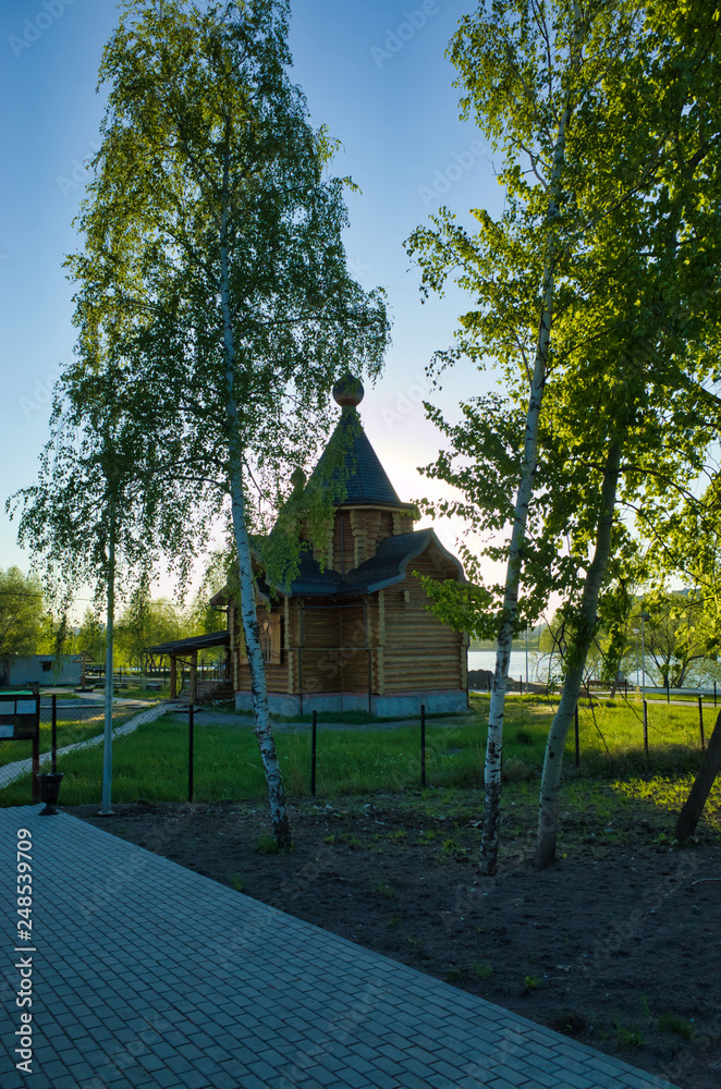 Fototapeta premium MOSCOW, RUSSIA - MAY 10, 2018: Brateevsky cascade park on the bank of the Moscow River. Wooden church by the pond