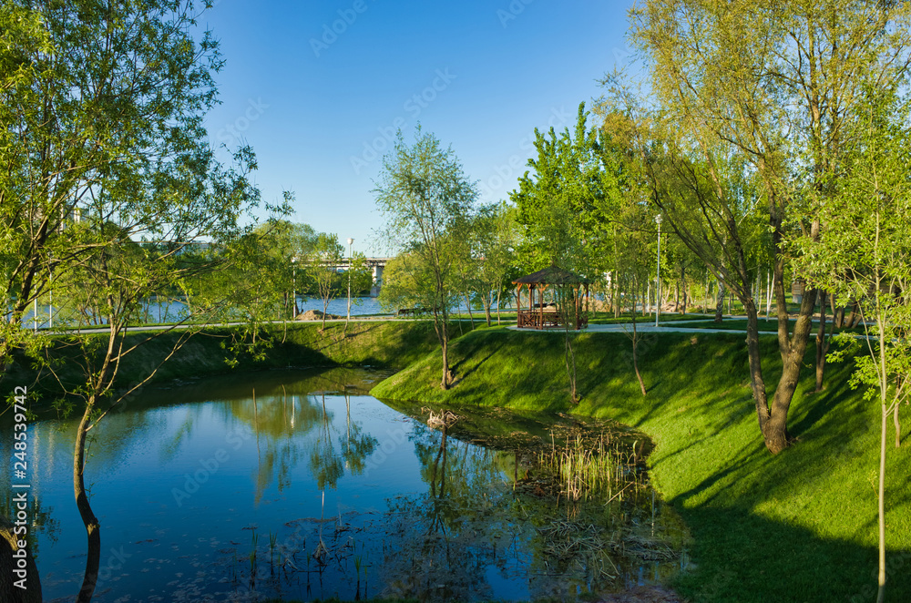 MOSCOW, RUSSIA - MAY 10, 2018: Brateevsky Park. Place of recreation and entertainment, a wooden gazebo by the pond MOSCOW, RUSSIA - MAY 10, 2018: Brateevsky Park. Place of recreation and entertainment, a wooden gazebo by the pond