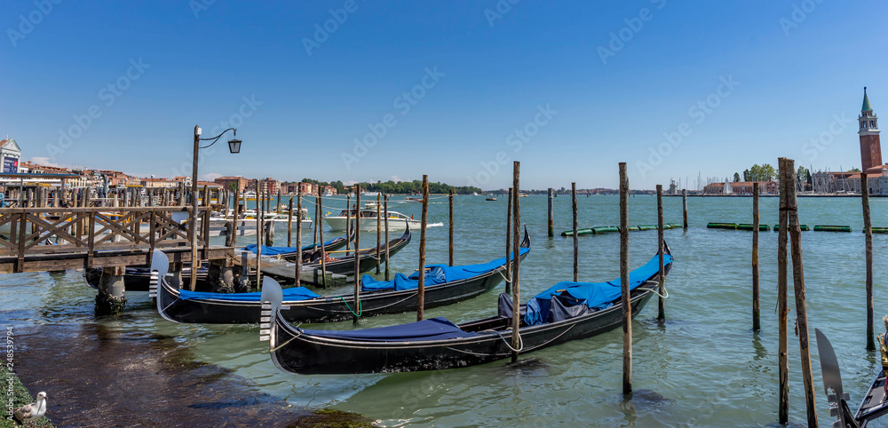 Gondolas moored by Saint Mark square in Venice, Italy at claudy day