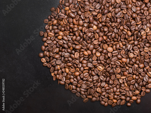 Coffee in beans on dark background. Abstract Food background texture, roasted coffee beans, top view