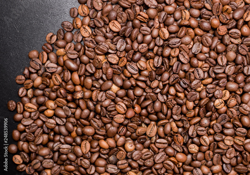 Coffee in beans on dark background. Abstract Food background texture  roasted coffee beans  top view