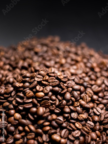 Coffee in beans on dark background. Abstract Food background texture, roasted coffee beans