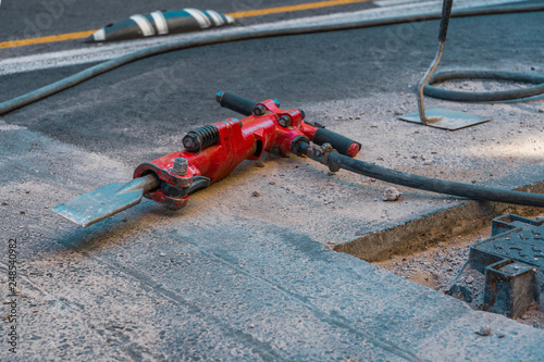 Red jackhammer at construction site.