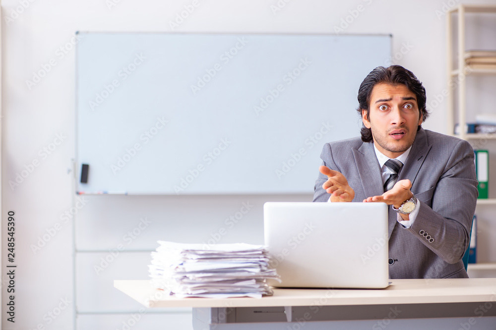 Young handsome businessman employee in the office Young handsome businessman employee in the office