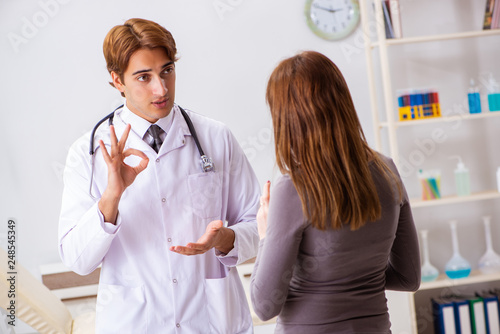 Deaf-mute female patient visiting young male doctor photo