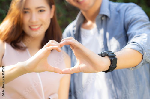 Closeup of happy couple fun making gesture heart shape with hand outdoor together  man and woman with relation feeling love with symbol and sign  lover and romantic concept.