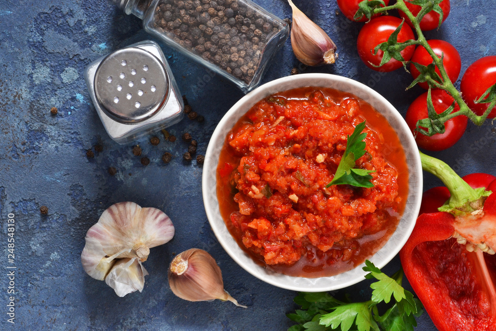 Tomato sauce with peppers, spices and herbs on the kitchen table. View from above. Tomato sauce with peppers, spices and herbs on the kitchen table. View from above.