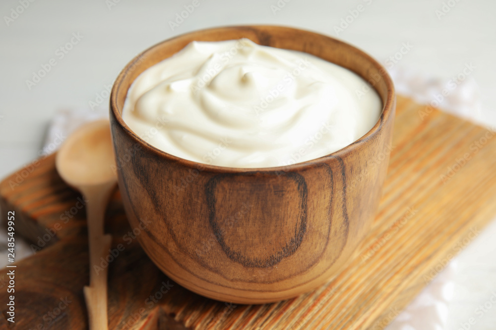 Wooden bowl with creamy yogurt served on table Wooden bowl with creamy yogurt served on table