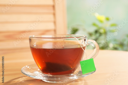 Brewing tea with bag in cup on table
