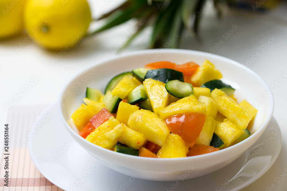 Fruit salad with pineapple, cucumber and tomato in bowl Fruit salad with pineapple, cucumber and tomato in bowl