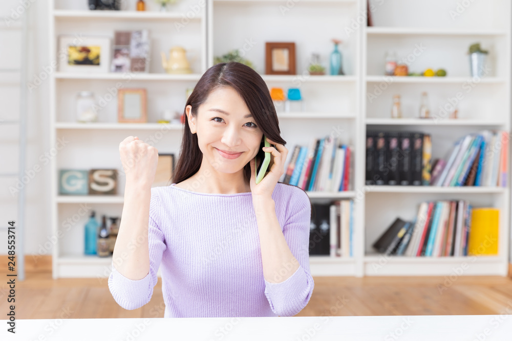 部屋で電話をする女性 部屋で電話をする女性