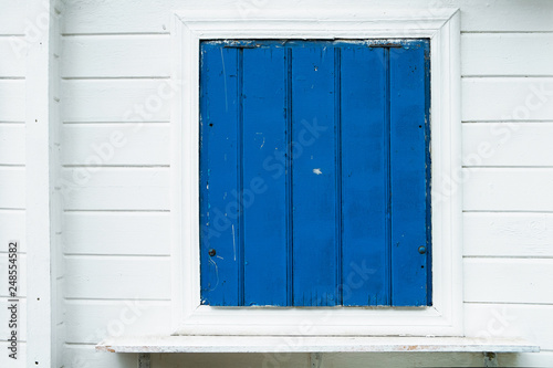 Blue wooden window with white wall