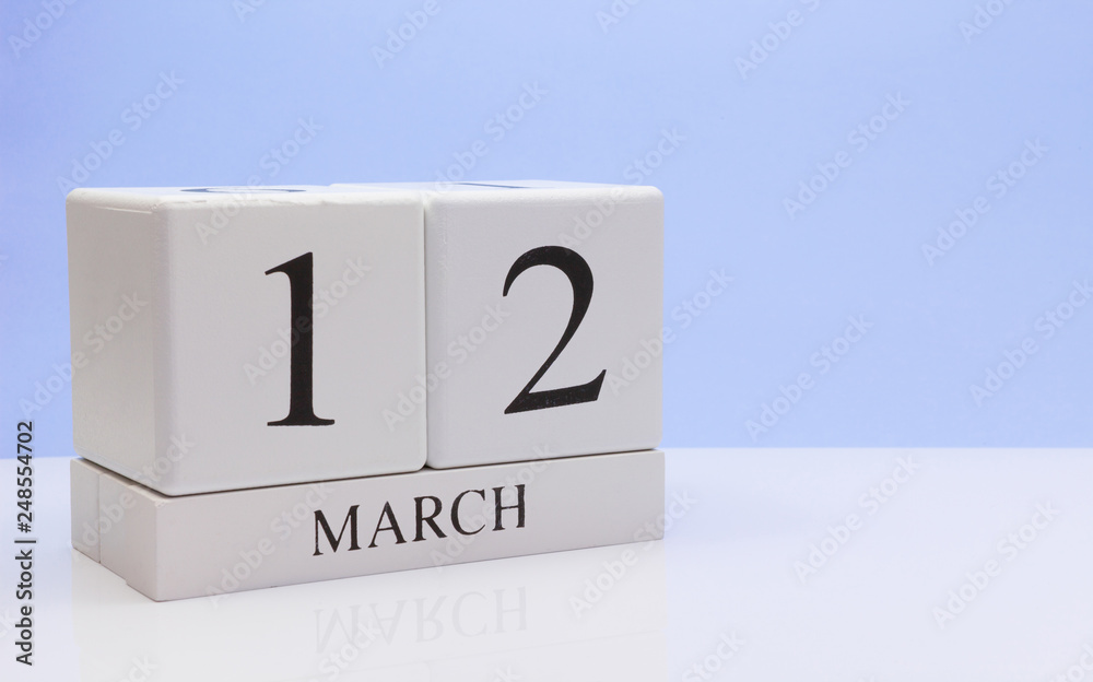 March 12st. Day 12 of month, daily calendar on white table with reflection, with light blue background. Spring time, empty space for text