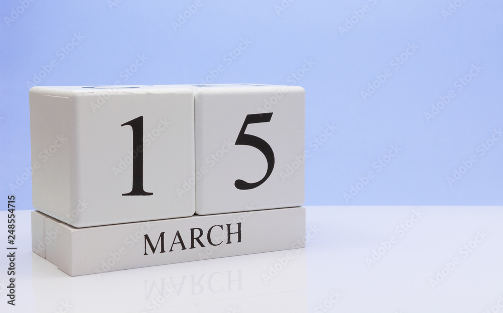 March 15st. Day 15 of month, daily calendar on white table with reflection, with light blue background. Spring time, empty space for text