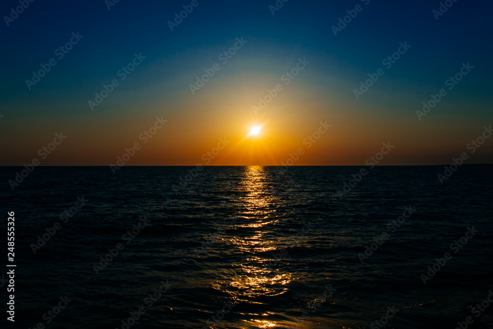 Fototapeta premium Sunset on the sea or ocean with beautiful blue sky. Sunset or sunrise scene landscape background concept image.