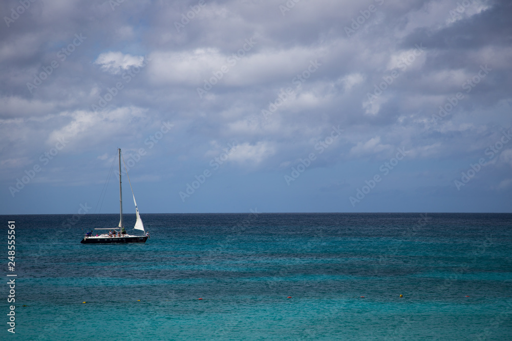 Sailboat cruising by the beach in Aruba