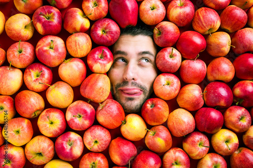 Mann mit Äpfeln , Konzept für Lebensmittelindustrie. Gesicht von lachenden mann  in Apfel Fläche.