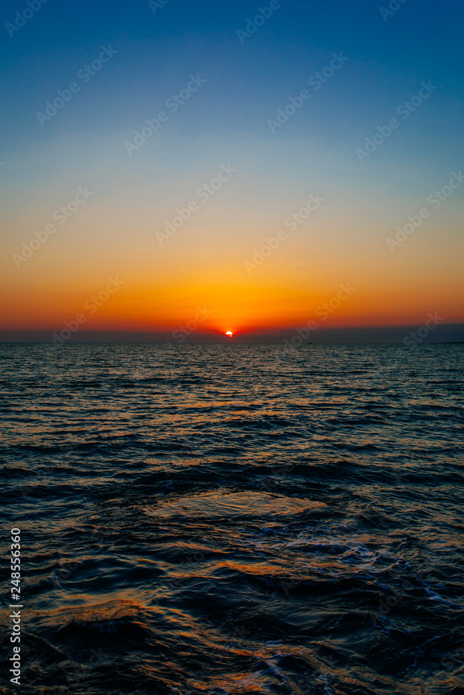 Sunset on the sea or ocean with beautiful blue sky. Sunset or sunrise scene landscape background concept image.