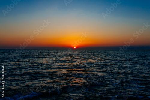 Sunset on the sea or ocean with beautiful blue sky. Sunset or sunrise scene landscape background concept image.