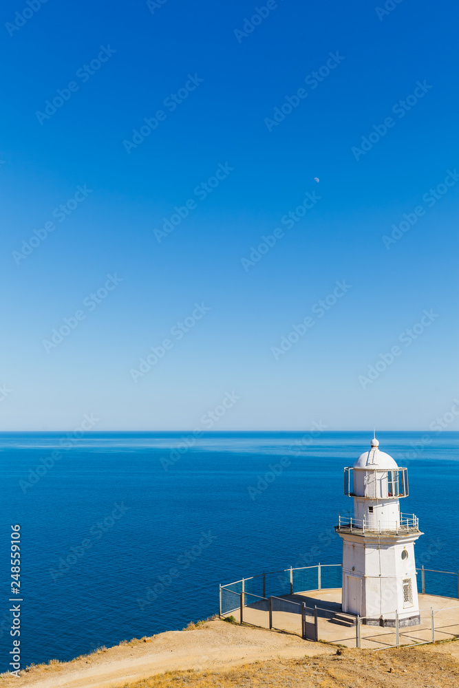 White lighthouse on a background of blue sea